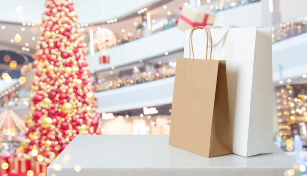 Christmas shopping bags on marble counter top with blurred festive mall background