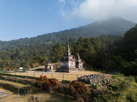 Aerial view of Gedong Songo Temple nestled in the lush forested slopes of Mount Ungaran with ancient stone structures and clear sky in Bandungan, Jawa Tengah, Indonesia.