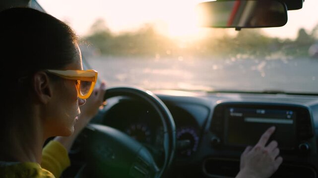 Woman using the car's touchscreen navigation system to select her travel destination