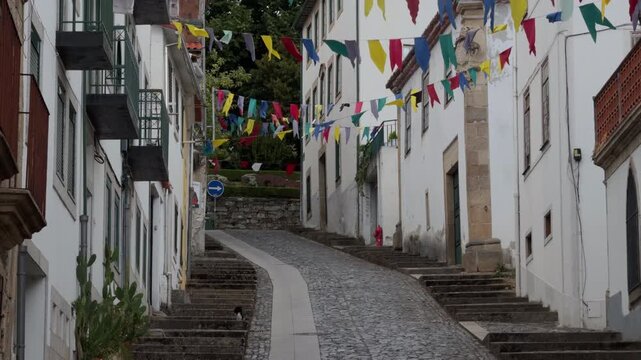 Colorful Festival Bunting Above Quiet Cobblestone Village Street