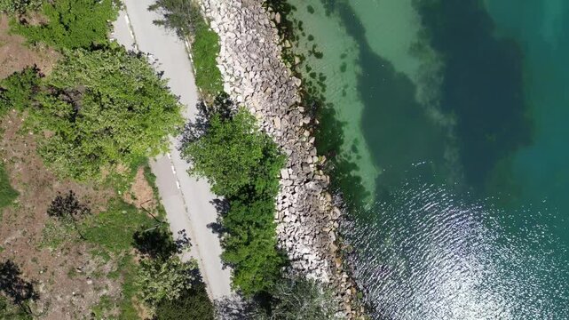 Aerial Top Down View of Rocky Coastline Turquoise Sea Water and Road