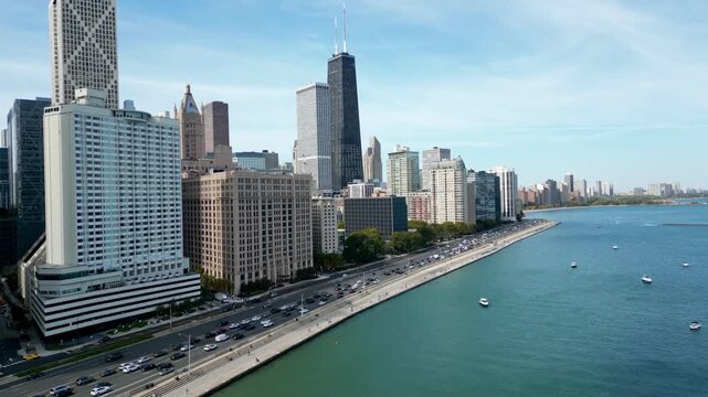 drone flying towards chicago skyline above lake michigan and city traffic