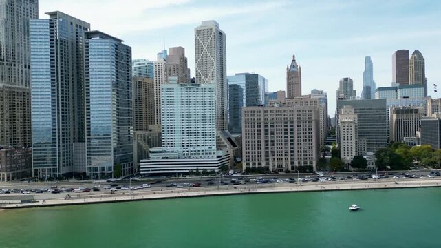 drone flying dramatically away from chicago skyline with cars and lake michigan below
