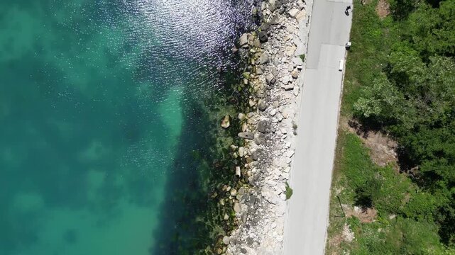Aerial Top Down View of Rocky Coastline Turquoise Sea Water and Road