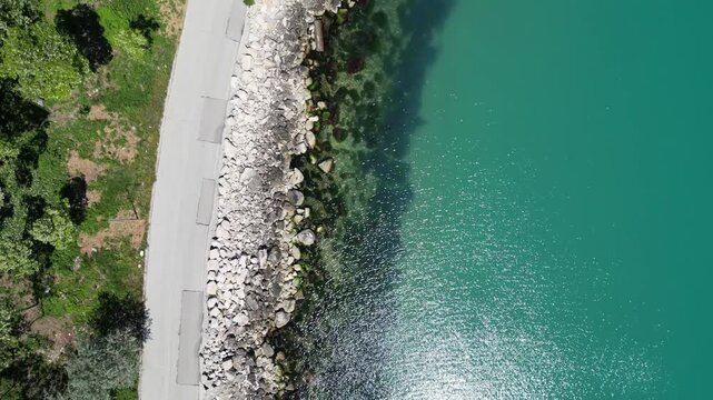 Aerial Top Down View of Rocky Coastline Turquoise Sea Water and Road
