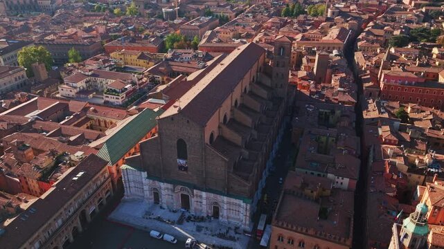 Aerial drone view of Basilica di San Petronio in Bologna, Italy, showcasing its monumental fa&ccedil;ade, historic architecture, Piazza Maggiore, and surrounding old town cityscape.