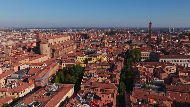 Aerial drone view of Bologna, Italy, showcasing the historic city center, terracotta rooftops, medieval towers, churches, urban architecture, and the Emilia-Romagna cityscape.