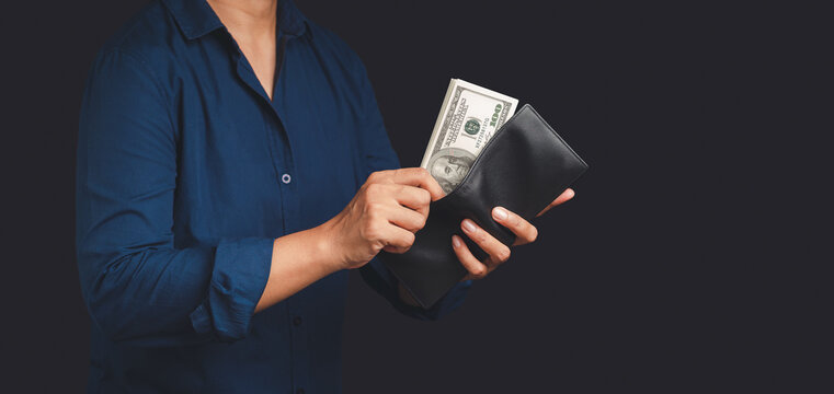Person holding open wallet with US dollar banknote  