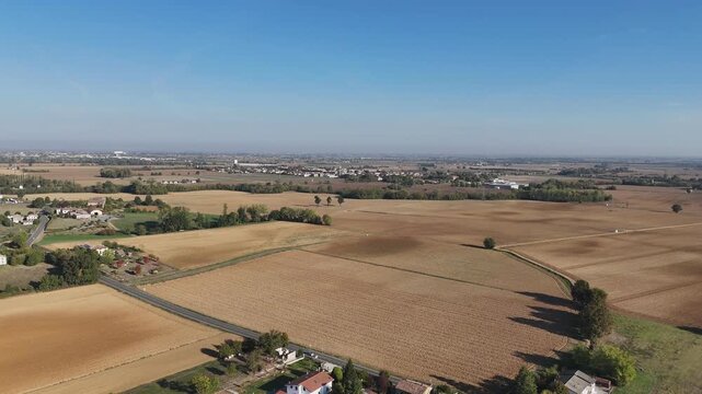Agricultural plain near Castelnuovo Fogliani and Alseno with extensive cultivated fields, rural roads, scattered farmhouses, tree lines and distant settlements across Po Valley, Piacenza, pullback