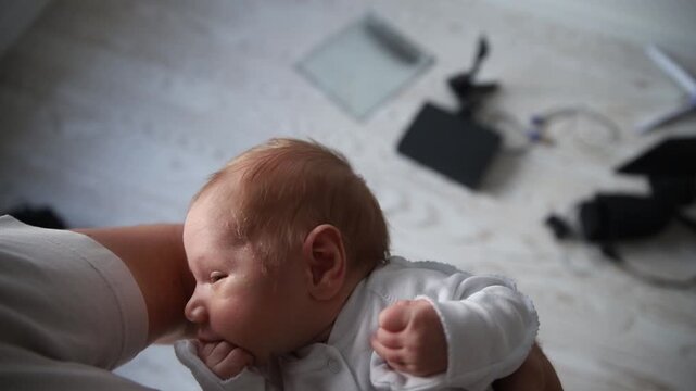 Tired newborn baby yawning and falling asleep in parent's arms