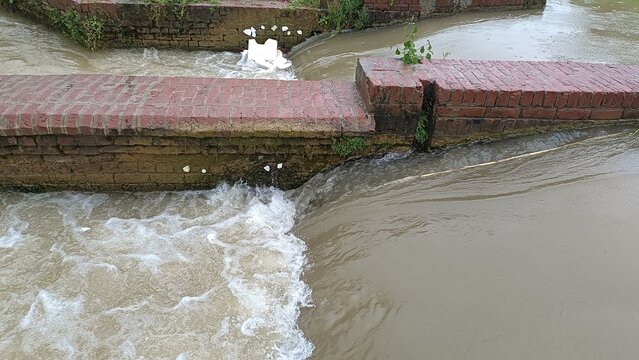 Foamy water cascading over a small river weir