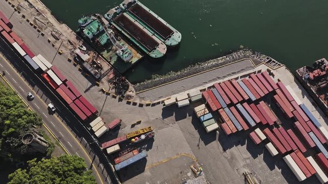 Directly overhead top-down aerial view of a container terminal yard, shipping containers, and docked barges