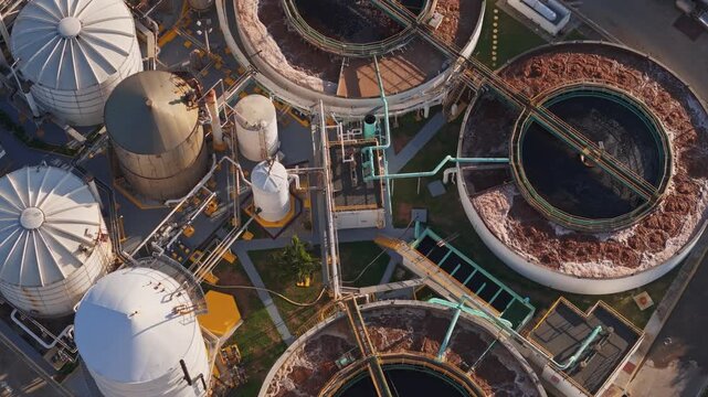Directly overhead top-down aerial view of an industrial water treatment plant with circular clarifiers and storage tanks
