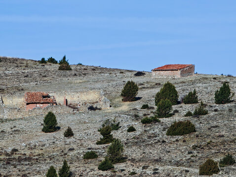 Remote rural landscape featuring abandoned stone ruins and cabin