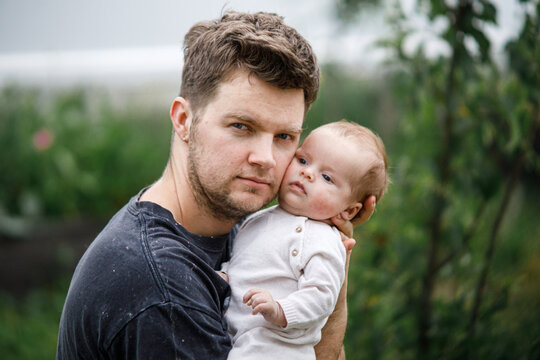 Father hugging cute newborn baby close up in the garden.Happy Fathers day! Love, care and family in countryside concept. Adoption and parenthood