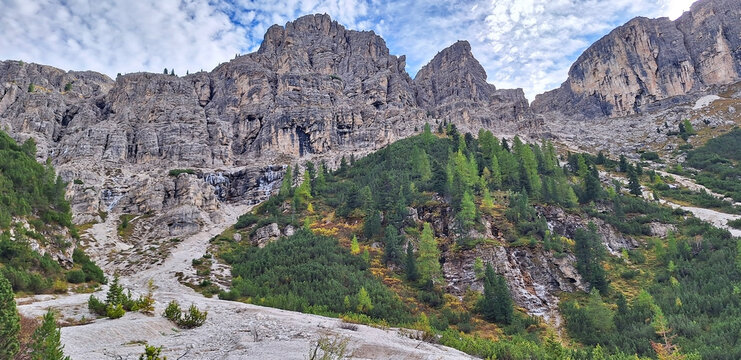 The winding Vallunga hiking trail among the rocks with a church in the Puez Geisler nature park in Selva. Panorama.