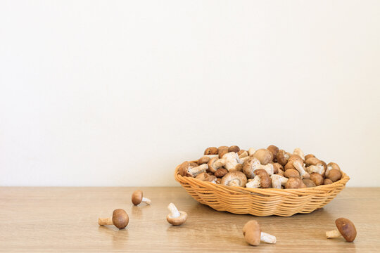 Fresh shiitake mushrooms in basket on wooden table, Raw shiitake mushrooms