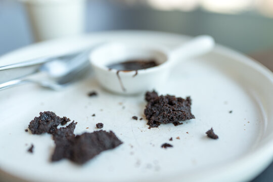 A white empty plate with piece of cake leftovers