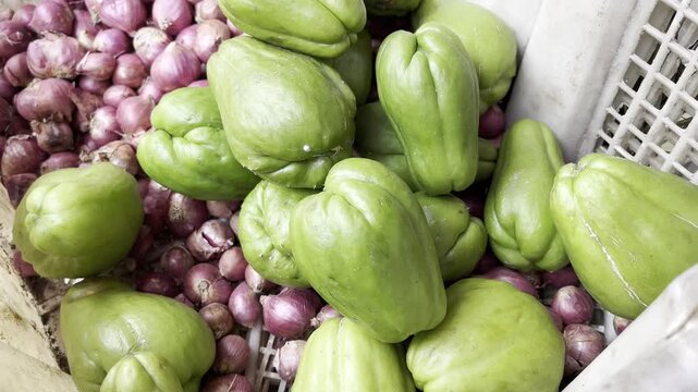 Fresh green chayote squash stack at traditional market