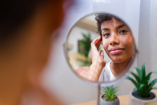 African American woman examining her face