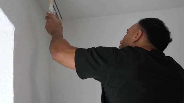 Professional Painter Using Brush to Paint Ceiling Corner White in Room Renovation Project Precision Detail Work DIY Home Improvement Concept Indoors
