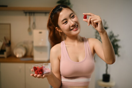 Young Asian Woman Holding Raspberries Showing Antioxidant Benefits for Skin Nourishment and Anti Aging Health