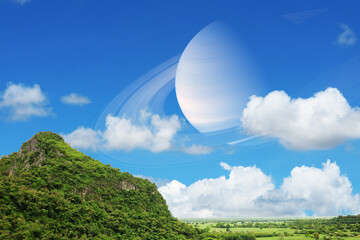 Saturn near earth back on the blue sky and white cloud over mountain © darkfoxelixir