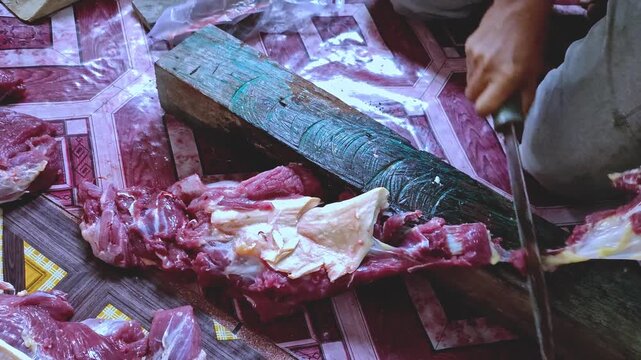 Hands slicing raw red meat with a knife close up
