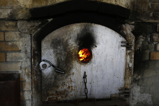 Flames blaze through the observation hole of a traditional brick furnace.