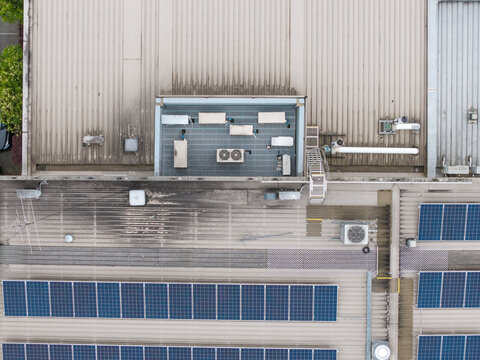 Aerial view of Bayswater North Factories featuring rows of solar panels and HVAC units on a corrugated metal roof in Melbourne, Victoria, Australia.