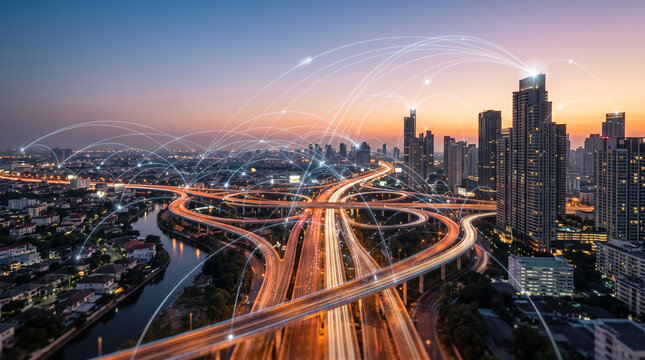 Smart city infrastructure with digital network connection lines over highway interchange and modern skyscrapers at sunset in bangkok, thailand