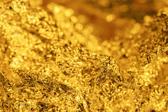 wrinkled texture of gold foil, metallic shine of crumpled thin metal background