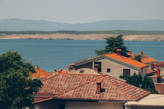 Elevated view of red terracotta rooftops in Crikvenica overlooking the blue Adriatic Sea and Krk Island in Kvarner Bay, Croatia.