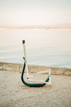Vertical shot of an outdoor public fitness elliptical machine installed along a seaside promenade facing calm waters.