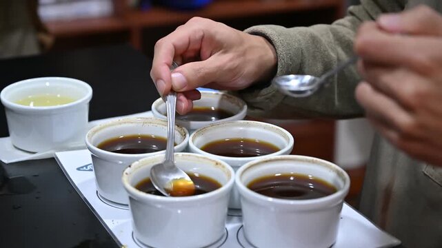 Professional barista cupping and tasting coffee samples