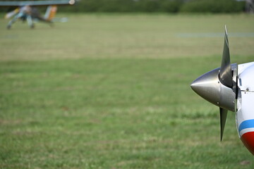 Close-Up of a Polished Stainless Steel Aircraft Propeller at a Grass Airfield © Miroslaw