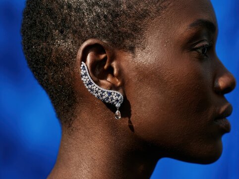Crystal ear cuff profile portrait on bold blue background