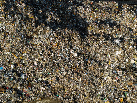 Aerial view of a large pile of mixed scrap metal and recyclable waste at a recycling facility in the United Kingdom.