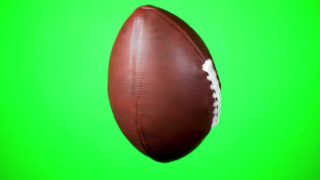 American football tumbling vertically in rotation on solid chroma key green screen background