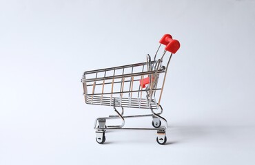 Small empty silver shopping cart on white background © Sunlight