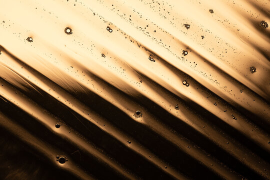 Abstract gold liquid with oil bubbles and stripes