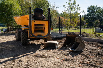 A yellow construction dump truck is parked at the construction site © Олеся Матвеева