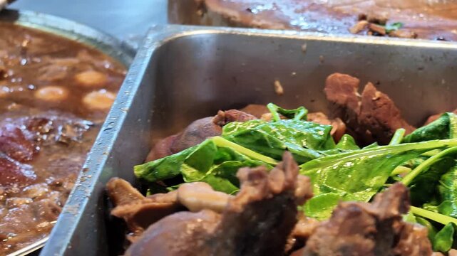 Braised Stewed Pork Knuckle Displayed on Metal Tray at Thai Market Stall with Panning Shot