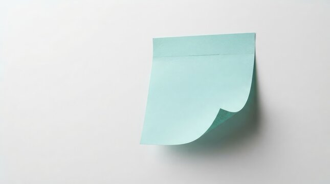 Single turquoise sticky note attached to a white surface with a partially peeled corner