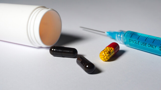 Close up of capsules and a syringe, also a medical bottle. Medication concept. 