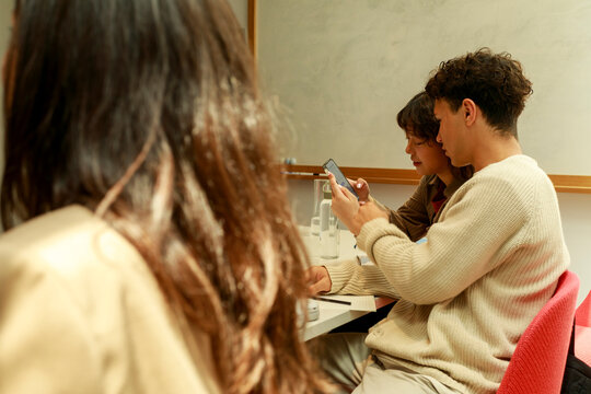 Group of People Using Phones in a Meeting Room During a Session