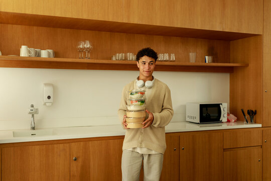 Person Carries Food Containers in Kitchen