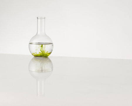 A round bottom laboratory flask with green liquid