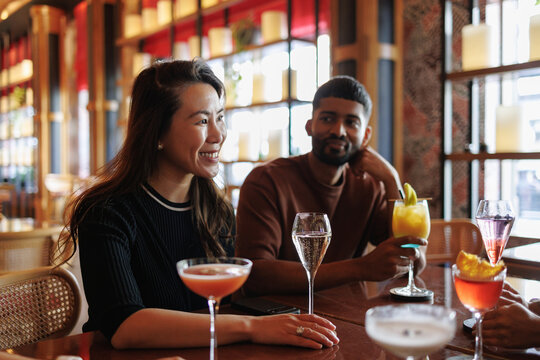 Diverse friends enjoying cocktails and socializing at bar
