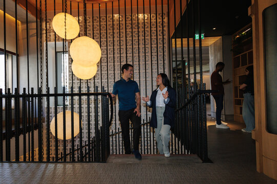 Professionals networking and discussing on modern office staircase
